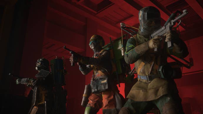 A mood of three members of the fire team, standing in a red light corridor